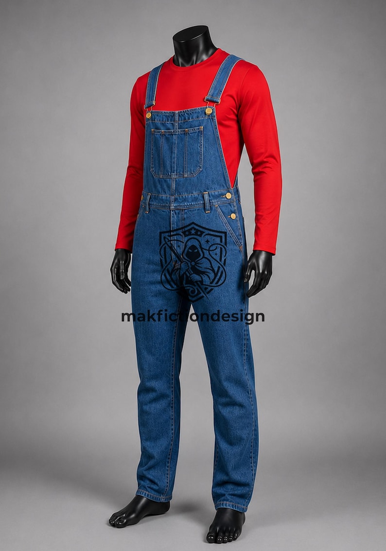 Puede incluir: Un peto de mezclilla azul con un bolsillo en el peto y botones de metal, usado sobre una camisa roja de manga larga. Un logotipo gr&aacute;fico negro que muestra una figura encapuchada y el texto makfictiondesign est&aacute; impreso en la tela vaquera.