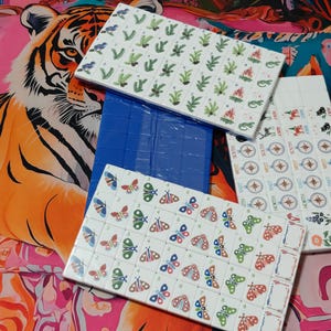 Nature inspired American Mahjong tile set with woodland illustrations, butterfly dot tiles, pine branch bam tiles, firefly mason jar craks, mushroom flower tiles, compass wind tiles, whimsical forest Mahjong set, cottagecore Mahjong tiles, collectible Mahjong game set, luxury Mahjong tiles, aesthetic board game décor, botanical Mahjong collection, artistic Mahjong gift for nature lovers and cozy game nights