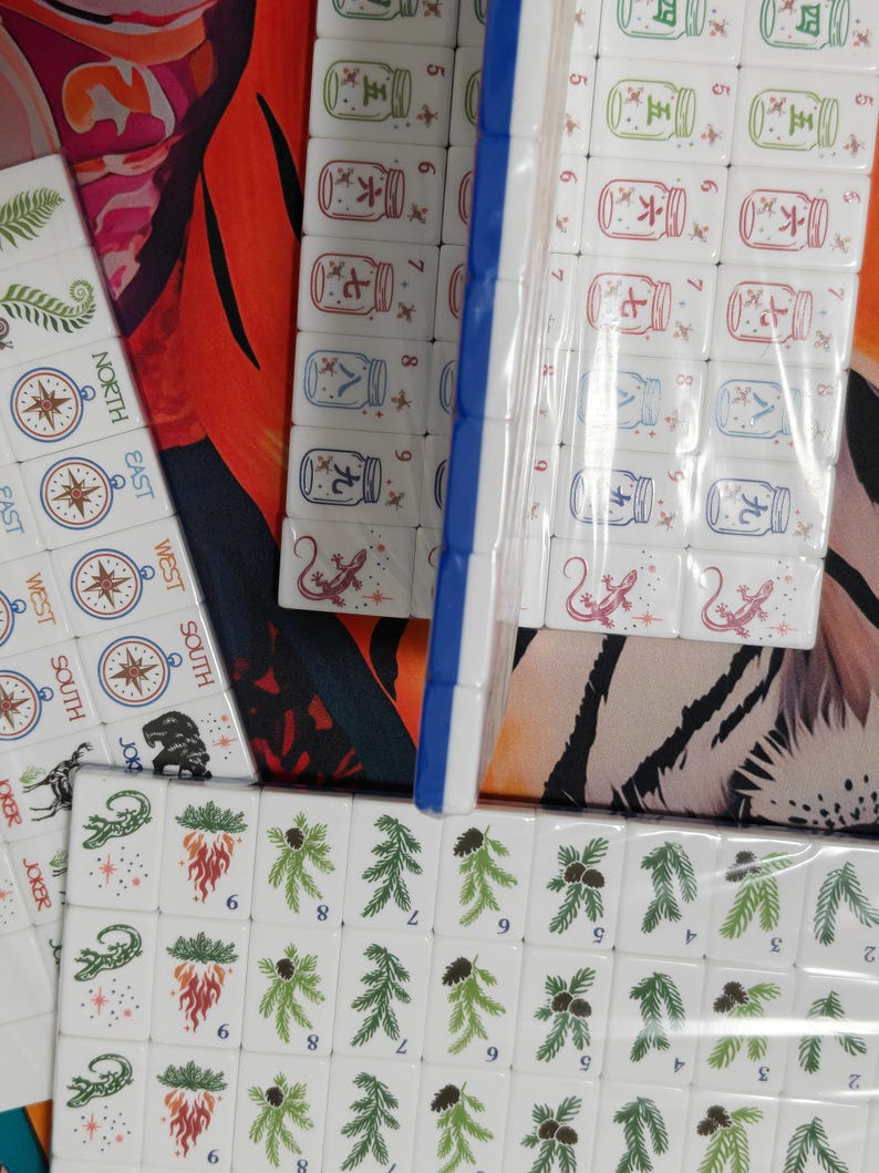 Nature inspired American Mahjong tile set with woodland illustrations, butterfly dot tiles, pine branch bam tiles, firefly mason jar craks, mushroom flower tiles, compass wind tiles, whimsical forest Mahjong set, cottagecore Mahjong tiles, collectible Mahjong game set, luxury Mahjong tiles, aesthetic board game décor, botanical Mahjong collection, artistic Mahjong gift for nature lovers and cozy game nights