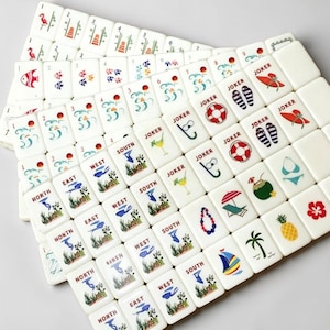 May include: A set of white Mahjong tiles with colorful illustrations. The tiles feature images of fish, flowers, and tropical items. Some tiles have the words "Joker", "North", "East", "West", and "South".