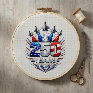 May include: Cross-stitch embroidery in a wooden hoop. The design features the number "250" in silver, red, and blue, with jets and the text "YEARS 1776-2026". A spool of thread and scissors are visible.