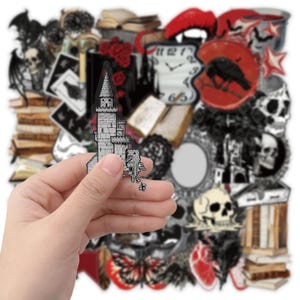 May include: A collection of gothic-themed stickers featuring various illustrations including a grey stone castle, skulls, red roses, a raven, a melting clock, books, a heart, and butterflies, all arranged in a dense, overlapping collage format.