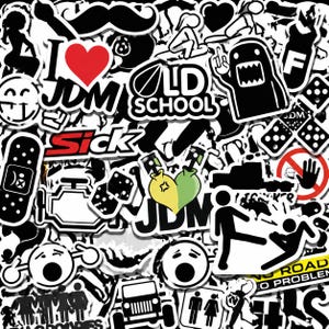 May include: A collection of black and white stickers with diverse designs. Features a red heart, the text "I JDM", "Old School", a cartoon monster, dice, and a no entry sign. The stickers have a glossy finish.