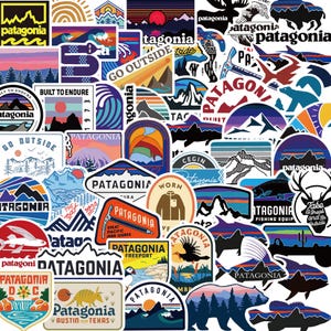 May include: A selection of Patagonia brand stickers with outdoor-themed designs. The stickers feature mountains, sunsets, wildlife, and the Patagonia logo in various colours, including blue, orange, and purple. The stickers are of different shapes and sizes.