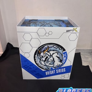 May include: White box with a blue and white design featuring a dragon-like creature and the text "BRIGHT SIRIUS". The box also has the text "LET IT RIP!" and "BLADERS BAZAR" in a neon-style font.