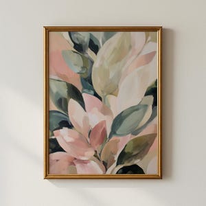 Op de afbeelding: Abstracte botanische kunstprint in een gouden lijst. Het kunstwerk toont een cluster van grote bladeren in tinten roze, groen en crème. Het schilderij heeft een zachte, schilderachtige stijl, met zichtbare penseelstreken en een gedempt kleurenpalet.