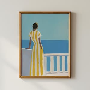 May include: Art print in a gold frame. It depicts a person in a yellow and white striped dress, standing on a white balcony, looking out at a blue sea. The background is a blue sky.