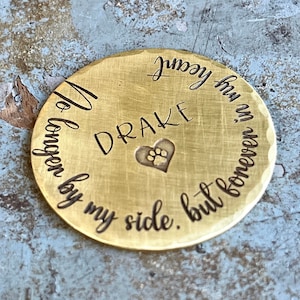 May include: A gold-colored metal disc with the inscription "You are no longer by my side, but forever in my heart" and the name "DRAKE" engraved on it. A paw print is inside a heart.