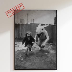 Puede incluir: Impresión en blanco y negro enmarcada que muestra a un niño corriendo con una gran figura de conejo. La imagen tiene una estética vintage e incluye el texto "PARALLEL WORLDS ARE" en un sello rojo. La expresión del conejo es amenazante.