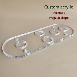 May include: Clear acrylic item with an irregular shape. It features several circular cutouts. The text "Custom acrylic thickness irregular shape" is visible in green and red.