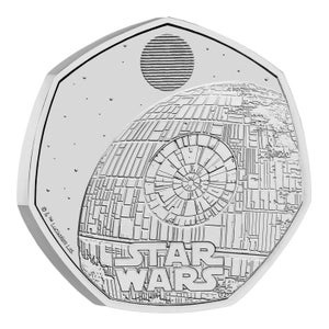 May include: A silver-coloured heptagonal coin featuring a detailed relief of the Death Star space station from Star Wars. The design includes a large circular laser dish, intricate surface paneling, a small planet above, and the Star Wars logo text.