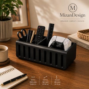 Pode incluir: Um organizador de secretária retangular preto com ranhuras verticais, contendo tesouras, canetas, um comando, uma régua e um comando de jogo branco. O texto MizanDesign é visível, com dimensões de 250 mm de largura, 90 mm de profundidade e 80 mm de altura.
