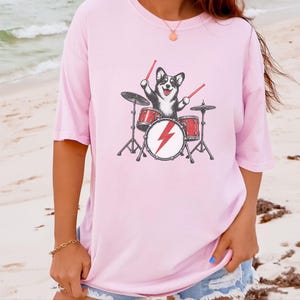 Maglietta per papà Corgi, idea regalo per batterista, maglietta rock con cane, maglietta per appassionati di musica, Corgi che suona la batteria, regalo divertente per amanti dei cani, maglietta con merchandising di una band immagine 9