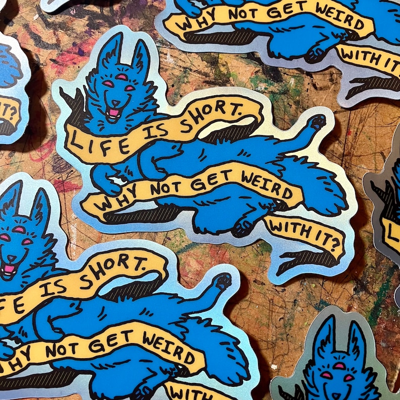 May include: A blue and yellow sticker with a cartoon dog with three eyes. The dog is holding a banner that says "Life is short. Why not get weird with it?"