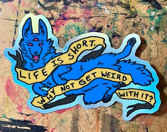 Op de afbeelding: Een blauwe en gele holografische sticker met een cartoonwolf met drie ogen. De wolf houdt een gele banner vast met de tekst: "Het leven is kort. Waarom niet gek worden?"