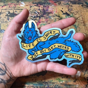 May include: A blue and yellow sticker with a cartoon wolf and the text "Life is short. Why not get weird with it?"