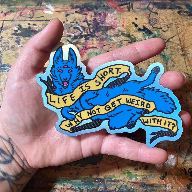 May include: A blue and yellow sticker with a cartoon wolf and the text "Life is short. Why not get weird with it?"