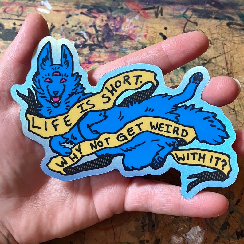 May include: A blue and yellow sticker with a cartoon wolf and the text "Life is short. Why not get weird with it?"