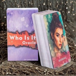 May include: A 78-card deck titled Who Is It Oracle with a purple box featuring a red banner and white text. Beside it, a card displays a watercolor-style portrait of a person with auburn hair in a bun, labeled Redhead in white text at the bottom.
