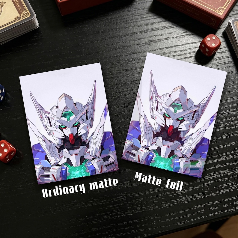 Op de afbeelding: Twee kaarthoezen met een gedetailleerde illustratie van een robot in wit, blauw en paars. E&eacute;n hoes is gemarkeerd met "Ordinary matte" en de andere met "Matte foil".