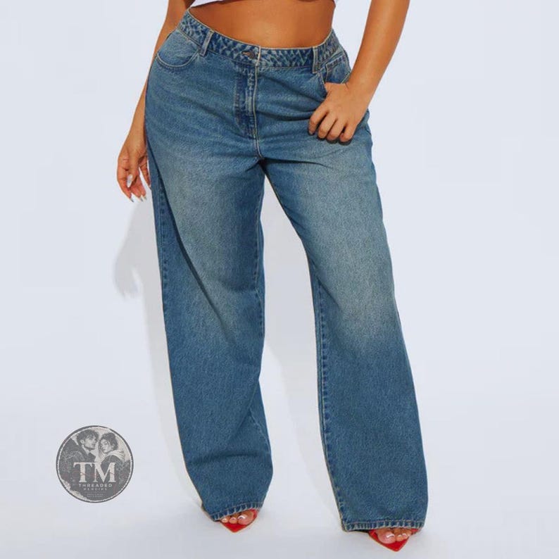 May include: High-waisted blue denim jeans with a wide-leg silhouette, featuring a classic five-pocket design, a button and zipper fly closure, and a medium wash finish. The jeans have a relaxed fit through the legs and a structured waistband.