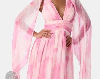 May include: A floor-length sleeveless dress featuring a pink and white watercolor-style abstract print. The garment has a deep V-neckline, a gathered waist, and long, flowing sheer cape-style sleeves that extend from the shoulders to the floor.