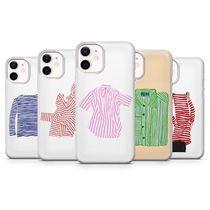 Può includere: Una collezione di custodie trasparenti per telefoni, ognuna con un design di camicia unico. Le camicie includono strisce blu e bianche, strisce rosse, strisce rosa e bianche, strisce verdi e strisce rosse e bianche. Le custodie sono disposte in fila.