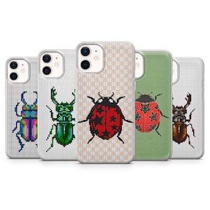 May include: Five clear phone cases arranged in a row, each featuring a unique pixel art insect design. The designs include a multicolored beetle, a green stag beetle, a red ladybug with black stars, a red beetle with stars, and a brown stag beetle.