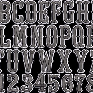 May include: An embroidered alphabet and number set in a western style. The letters and numbers are gray with a white border, set against a black background. The font is decorative and suitable for various craft projects.