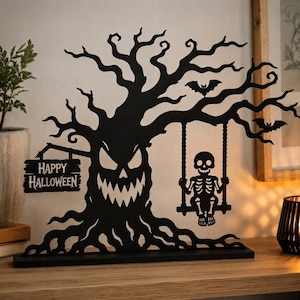 May include: A black metal Halloween decoration featuring a gnarled tree with a menacing face, a hanging sign that reads "HAPPY HALLOWEEN," a skeleton sitting on a swing suspended from a branch, and two small bats flying among the tree limbs.