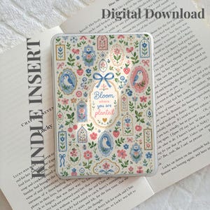 May include: A clear Kindle insert featuring a repeating pattern of blue birds, pink and blue flowers, strawberries, and ornate frames. The centre displays a blue bow above the text Bloom where you are planted in blue and pink script.