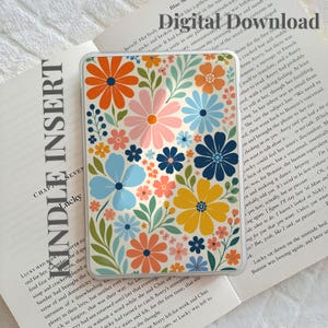 Puede incluir: Una lámina rectangular para Kindle con un patrón floral vibrante de flores naranjas, rosas, amarillas y azules intercaladas con hojas verdes. El texto Digital Download y Kindle Insert aparece impreso en la página tras la funda transparente.