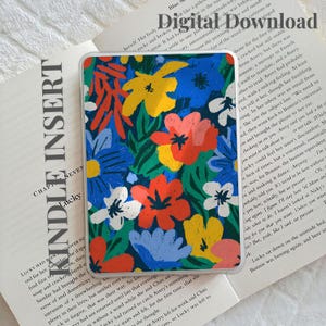Puede incluir: Una funda rectangular para lector electrónico con un vibrante patrón floral de flores rojas, amarillas, azules y blancas sobre un fondo azul oscuro. El texto Digital Download y KINDLE INSERT es visible en la página del libro abierto.