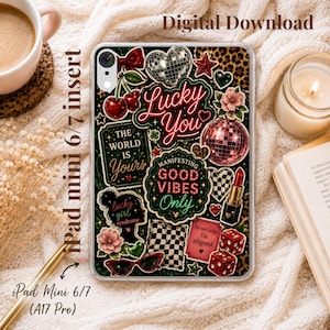May include: A clear tablet case featuring a collage of stickers including a disco ball, red cherries, a lipstick tube, dice, sunglasses, and text reading Lucky You, The World Is Yours, Manifesting Good Vibes Only, Lucky Girl Syndrome, and I'm not lucky, I'm aligned.