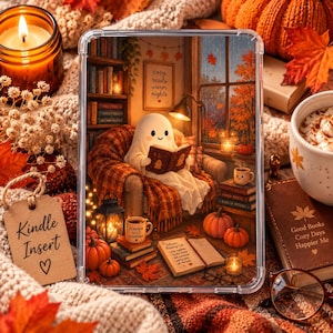 Può includere: Una custodia protettiva trasparente per e-reader con un'illustrazione stampata di un fantasma bianco seduto su una poltrona che legge un libro. La scena include librerie, zucche, una tazza con l'etichetta Pumpkin Spice e un libro aperto con il testo Autumn Reading List.