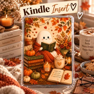 May include: A clear Kindle insert featuring a cute ghost reading a book, surrounded by autumn leaves, pumpkins, a candle labeled Sweater Weather, a mug of cocoa, and an open planner with the text today's plan: read a book, drink something warm, enjoy the little things.