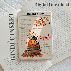 May include: A rectangular library card insert featuring a black cat sitting on a pumpkin atop a stack of books. The design includes autumn leaves, a crescent moon, a spider, and the text "LIBRARY CARD," "OVERDUE," and "Between the pages is where I feel at home."