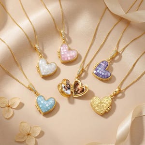 May include: A collection of gold-tone heart-shaped lockets on delicate chains. The lockets feature inlaid iridescent tiles in white, pink, blue, and purple. One locket is open, revealing two small photographs inside, while another displays an engraved star pattern.