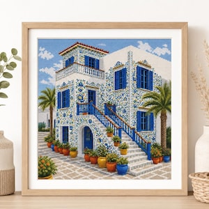May include: A framed cross-stitch embroidery depicting a white building with blue shutters and intricate blue and yellow floral tile patterns. The scene features a staircase with blue railings, potted plants, and palm trees under a blue sky.