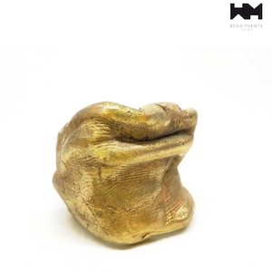 Op de afbeelding: Een gouden ring met een getextureerd, organisch ontwerp. De ring is gemaakt van metaal en heeft een unieke, abstracte vorm.