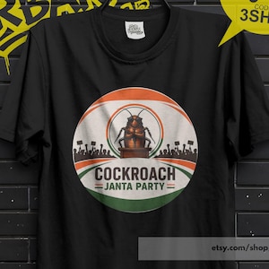 May include: Black t-shirt with a circular graphic featuring a cockroach and the text "COCKROACH JANTA PARTY". The design includes a silhouette of people holding signs. The shirt also has the text "BUY 3 FREE 3SHIP".