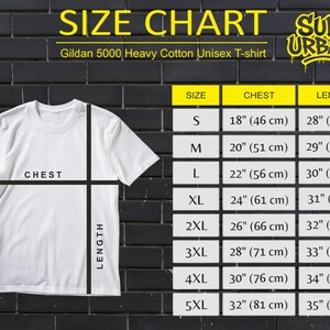 May include: A white Gildan 5000 Heavy Cotton Unisex T-shirt with a size chart. The chart lists chest and length measurements in inches and centimeters for sizes S through 5XL. The shirt is displayed against a black brick wall.