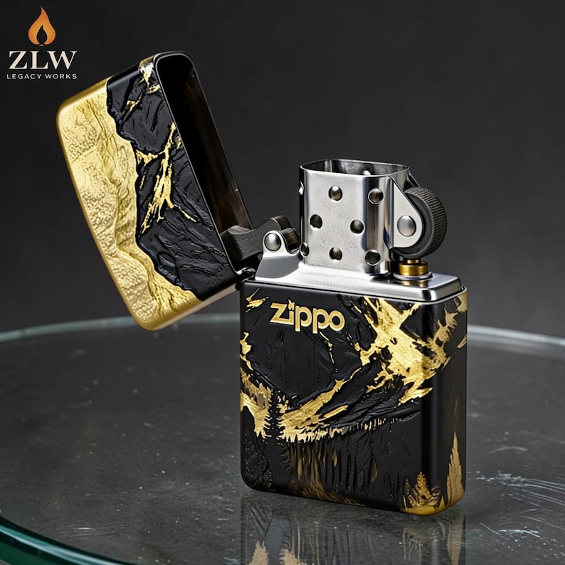 Może przedstawiać: Zapalniczka Zippo z czarno-złotym wzorem g&oacute;rskim. Zapalniczka jest otwarta, ukazując wnętrze. Logo Zippo jest widoczne z przodu. Logo ZLW Legacy Works znajduje się w lewym g&oacute;rnym rogu.