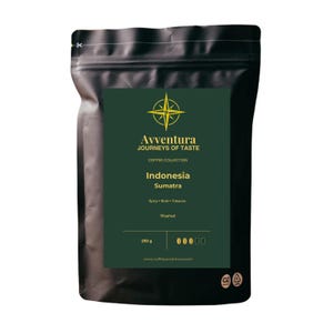 May include: A black coffee bag with a dark green label featuring a yellow compass logo, the text Avventura Journeys of Taste, Indonesia Sumatra, Spicy Bold Tobacco, Washed, 250 g, and a five-bean intensity scale with one bean filled in.