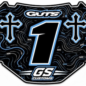 May include: A black and light blue motocross number plate decal featuring the number 1 in the center, the text GUTS at the top, and GS CUSTOMS at the bottom. The background has a topographic map pattern with cross symbols on both sides.