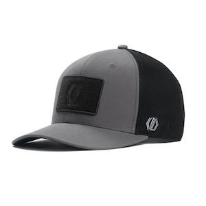 May include: A gray and black baseball cap with a curved brim. The front panel is gray with a black rectangular patch. The back of the cap is black mesh. A small logo is on the side.