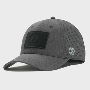 May include: A gray baseball cap with a curved brim and a perforated side panel. The cap features a black rectangular patch on the front and a white logo on the side. The cap is made of a textured fabric.