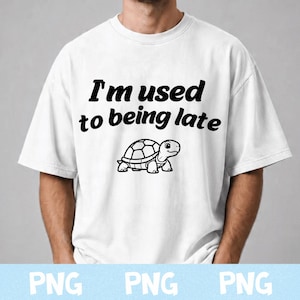 May include: A white short-sleeved t-shirt featuring the black text "I'm used to being late" printed in a bold, rounded font above a simple black and white line drawing of a small turtle facing toward the right side of the garment.