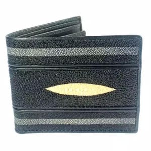 Puede incluir: Una cartera plegable con un exterior texturizado de rayas negras y grises. El panel central muestra una incrustación prominente, lisa y de color crema en forma de almendra. La cartera está construida con bandas horizontales de tonos.
