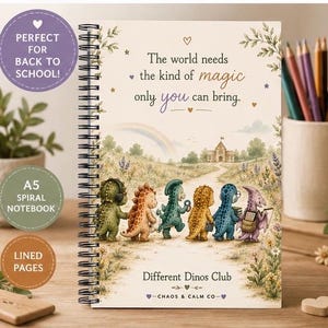 May include: A spiral-bound A5 notebook with a cream cover featuring a whimsical illustration of six colorful dinosaurs walking on a path toward a schoolhouse. The text reads: The world needs the kind of magic only you can bring. Different Dinos Club.